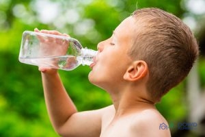 A Kid Drinking Water Outside