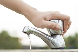 Hand on a Faucet Outside